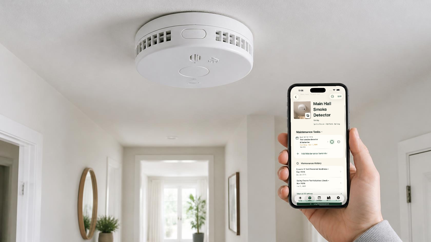 A hand holding an iPhone with the real Around The House smoke detector record open beneath a ceiling smoke alarm.